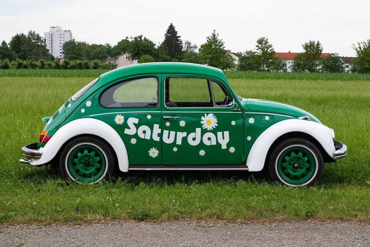 Zielony Garbus z napisem "Saturday" i stokrotkami, idealny na dzień wolny za święto w sobotę.