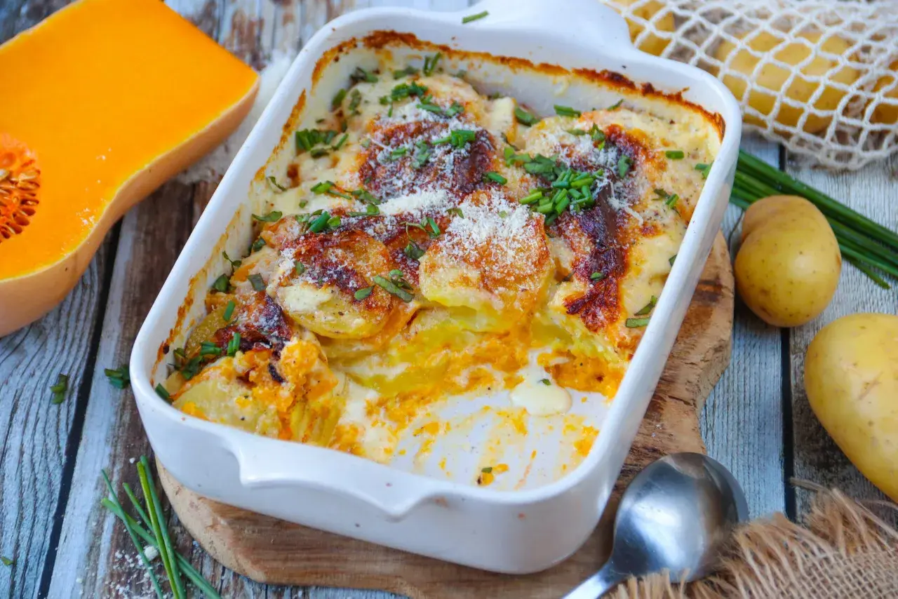 Gratin de butternut et pommes de terre, une recette réconfortante et savoureuse. Des rondelles dorées et crémeuses, parsemées de ciboulette fraîche.