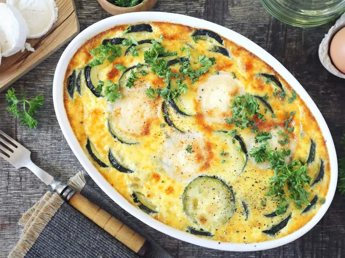 Clafoutis courgettes aux chèvres, garni de persil frais, prêt à être dégusté. Un délice simple et savoureux.