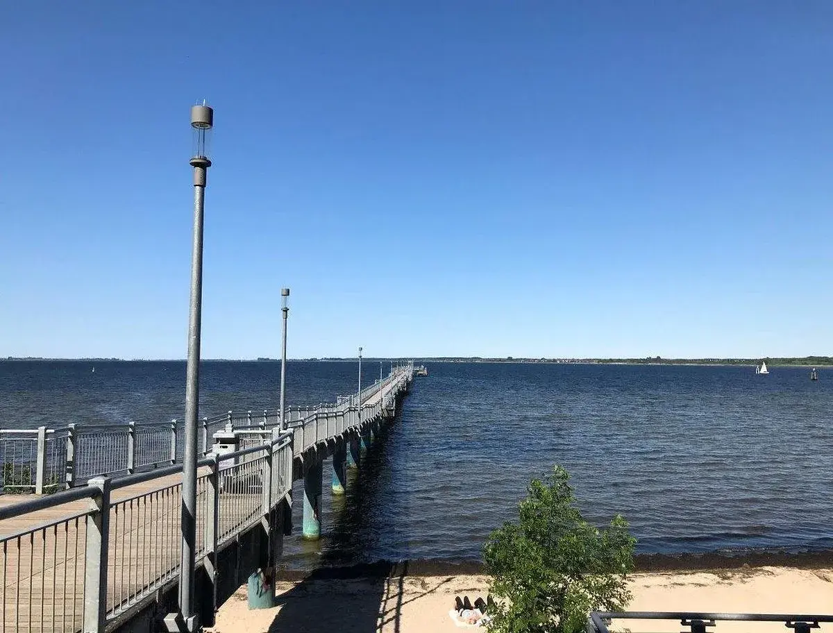 Langer Steg am Wismar Strand, der ins tiefblaue Wasser führt. Ein perfekter Ort für einen Spaziergang.
