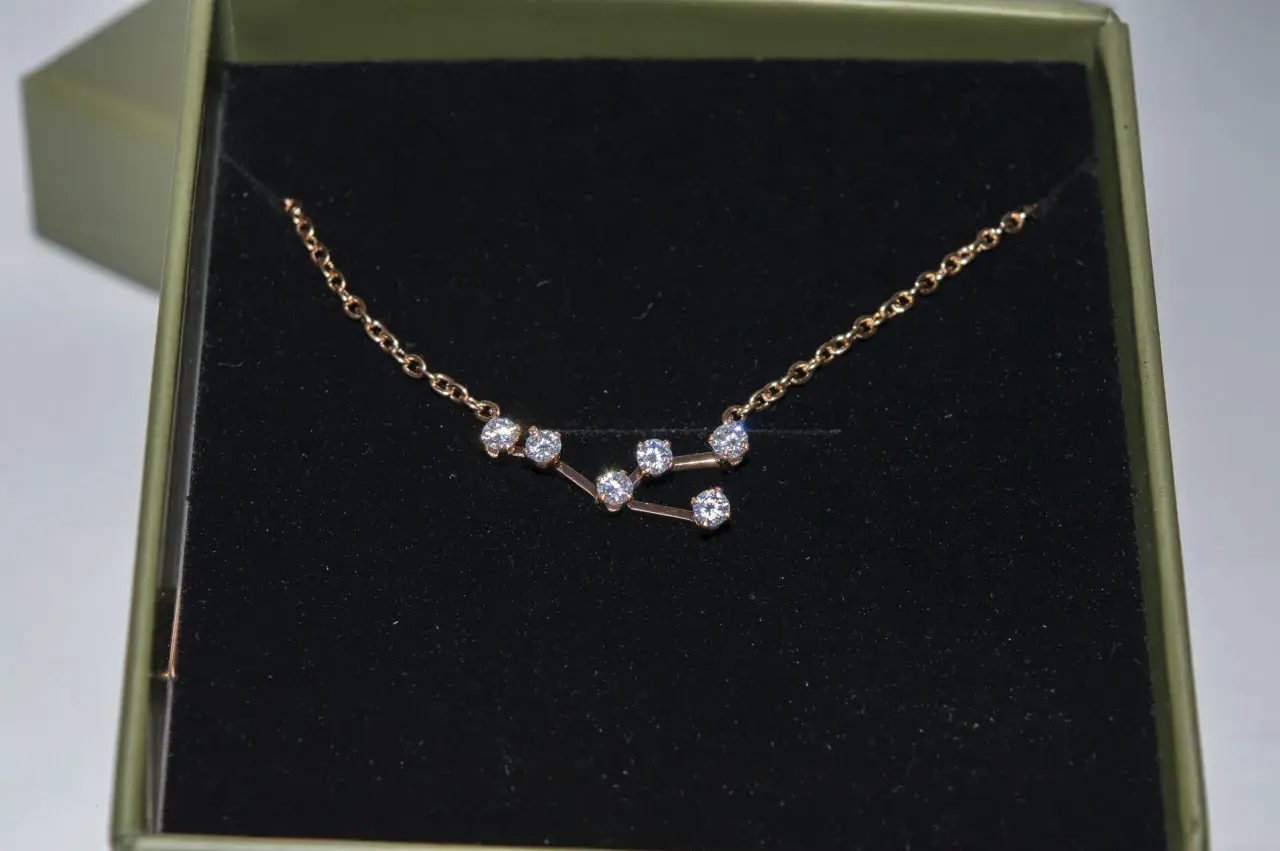 Colgante Tauro con circonitas brillantes en una caja verde.