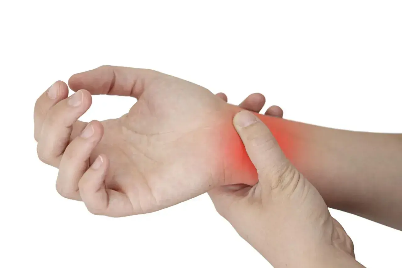 Una mano se presiona la muñeca, donde un área roja indica dolor por tendinitis.