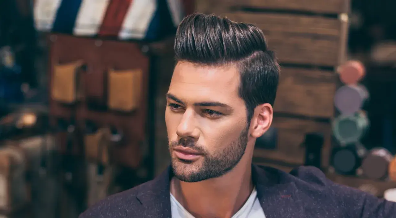 Hombre con peinado moderno y raya del pelo marcada a la derecha.
