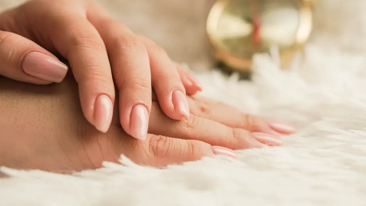Delikatne dłonie z różowym, naturalnym lakierem. Idealny manicure biologiczny dla każdej kobiety.