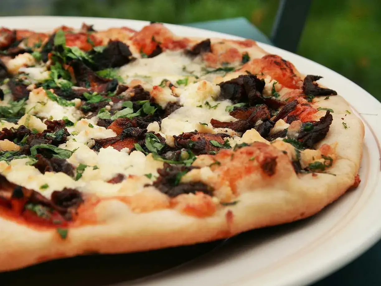 En härlig napolitansk pizza på grillen, med mörka svampar och krämig ost.