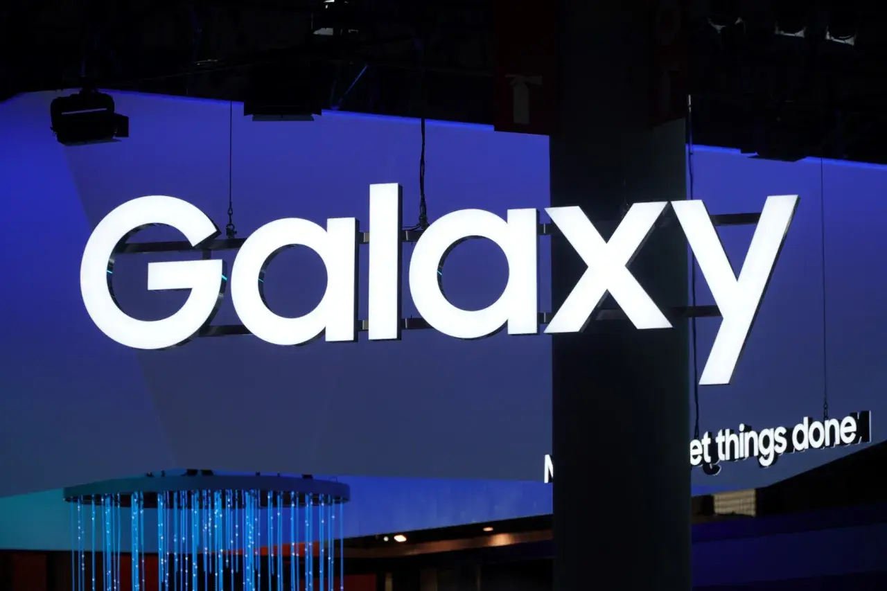 Jasne, oto tekst alternatywny:

Duży, biały napis "Galaxy" na niebieskim tle. Pod nim mniejszy napis "et things done". W tle widać elementy wystroju, w tym niebieskie światła. To wszystko nawiązuje do technologii i innowacji, które chroni **Knox**.