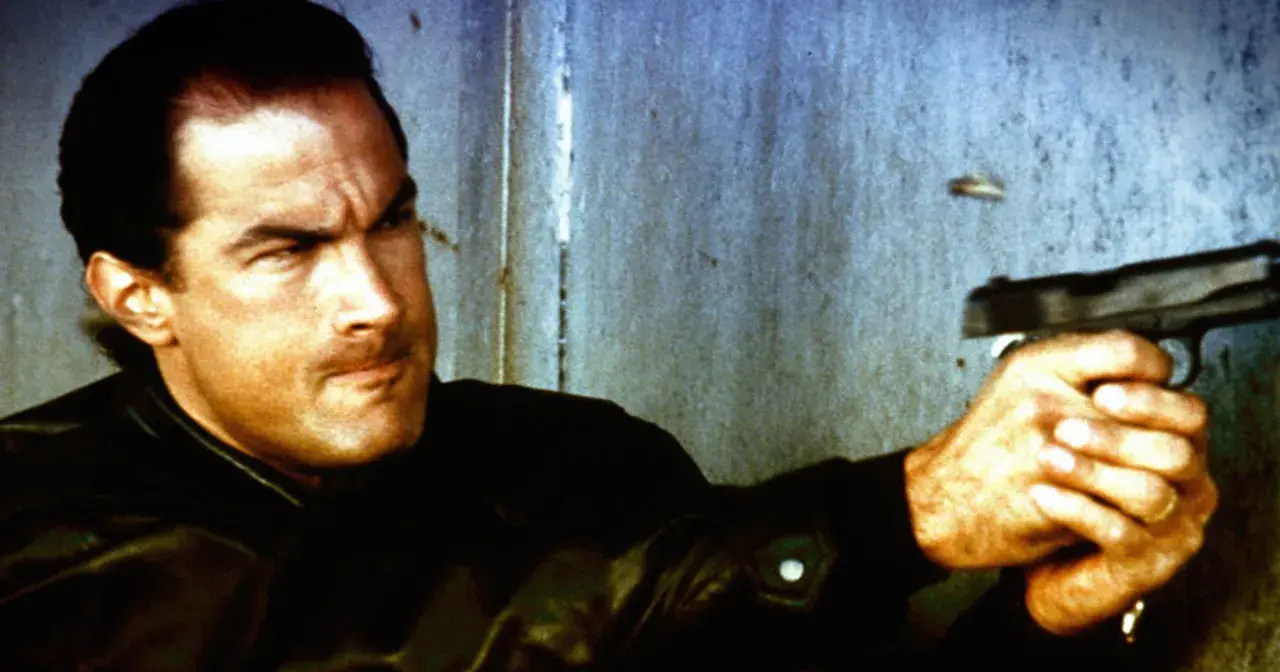 Steven Seagal jako Nico, policjant z filmu "Nico - ponad prawem", celuje z pistoletu.