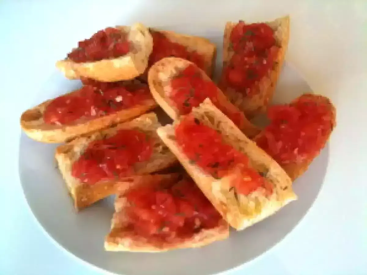 Des tranches de pain grillé garnies de tomates fraîches et d'herbes. Un délice simple et savoureux, parfait pour un apéritif.