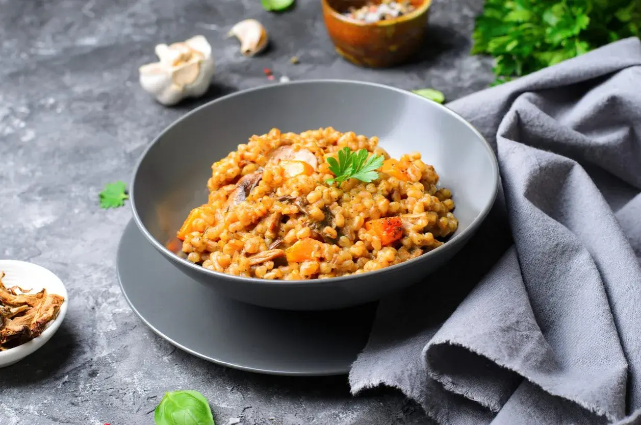Insalata di farro con funghi e verdure, guarnita con prezzemolo fresco. Un piatto gustoso e salutare.