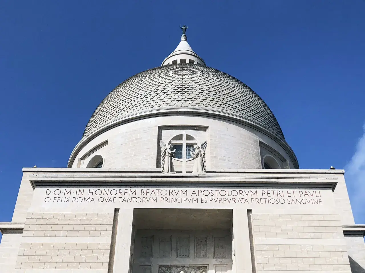 Cupola imponente di San Pietro e Paolo a Roma, con iscrizione latina che celebra la città e gli apostoli.