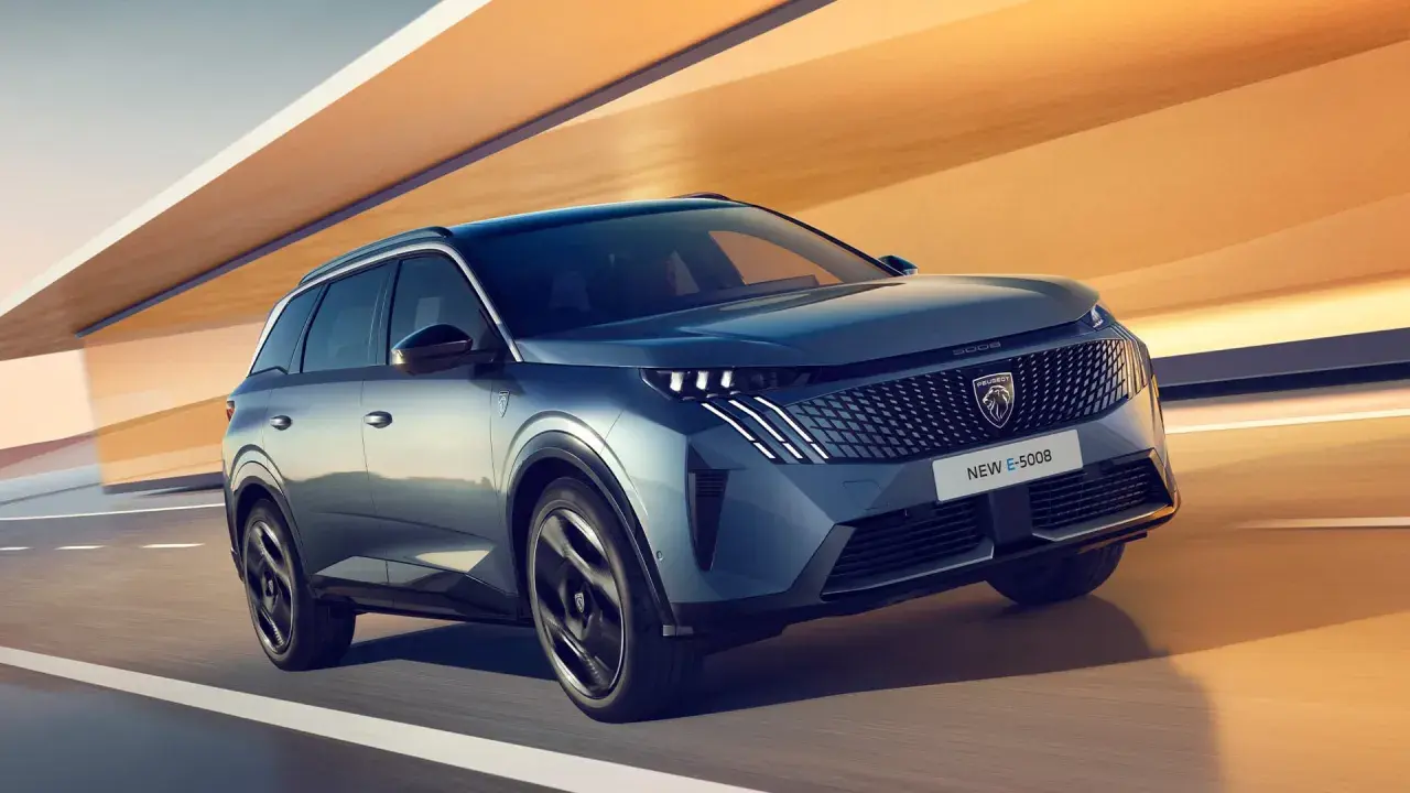 En blå Peugeot E-5008 glider fram på en väg, redo för ett spännande peugeot 5008 test.