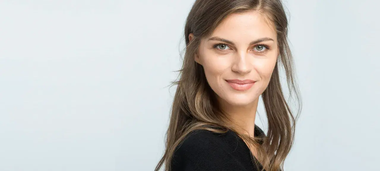 Mujer con un elegante corte de pelo media melena, mirada serena y una sonrisa sutil.