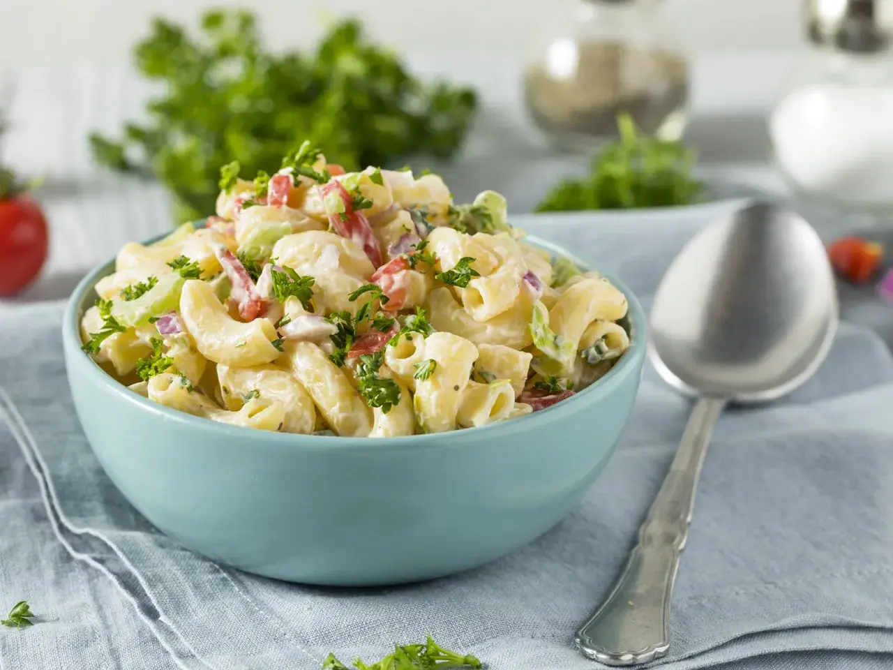 Cremiger Nudelsalat mit Joghurt, garniert mit frischer Petersilie. Perfekt für ein leichtes Mittagessen.