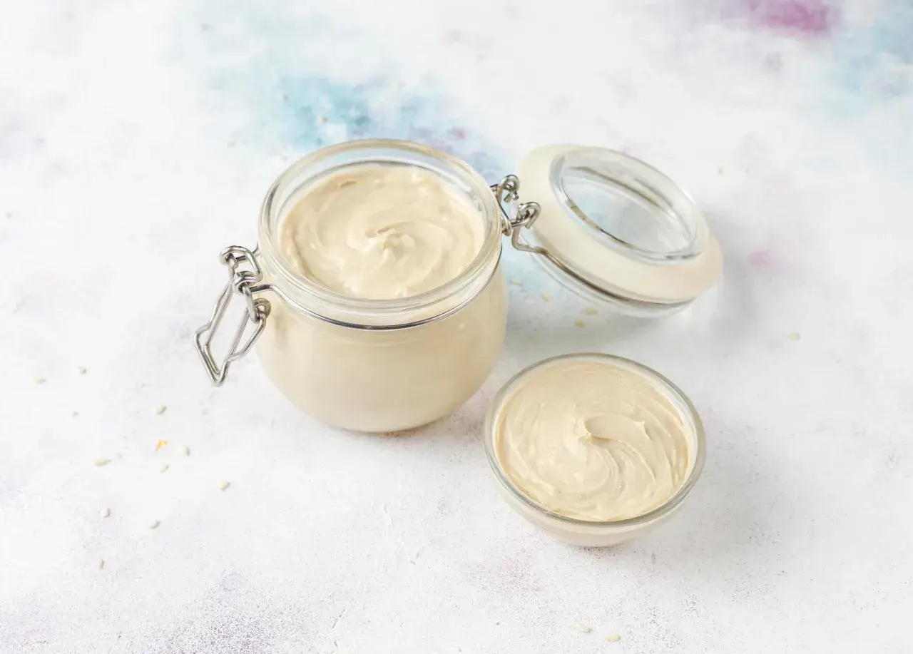 Un pot et un bol de crème onctueuse, prête à garnir vos pâtisseries.