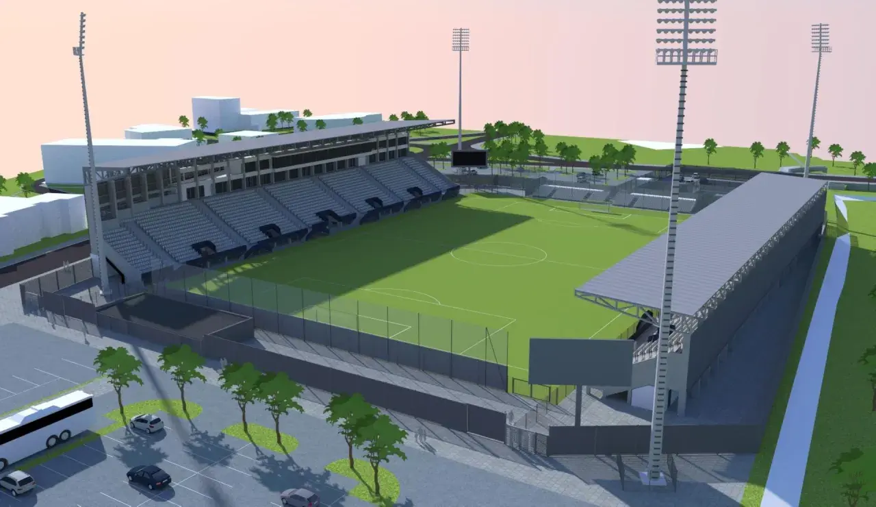 Nowoczesny stadion Sandecji z zieloną murawą, trybunami i oświetleniem.