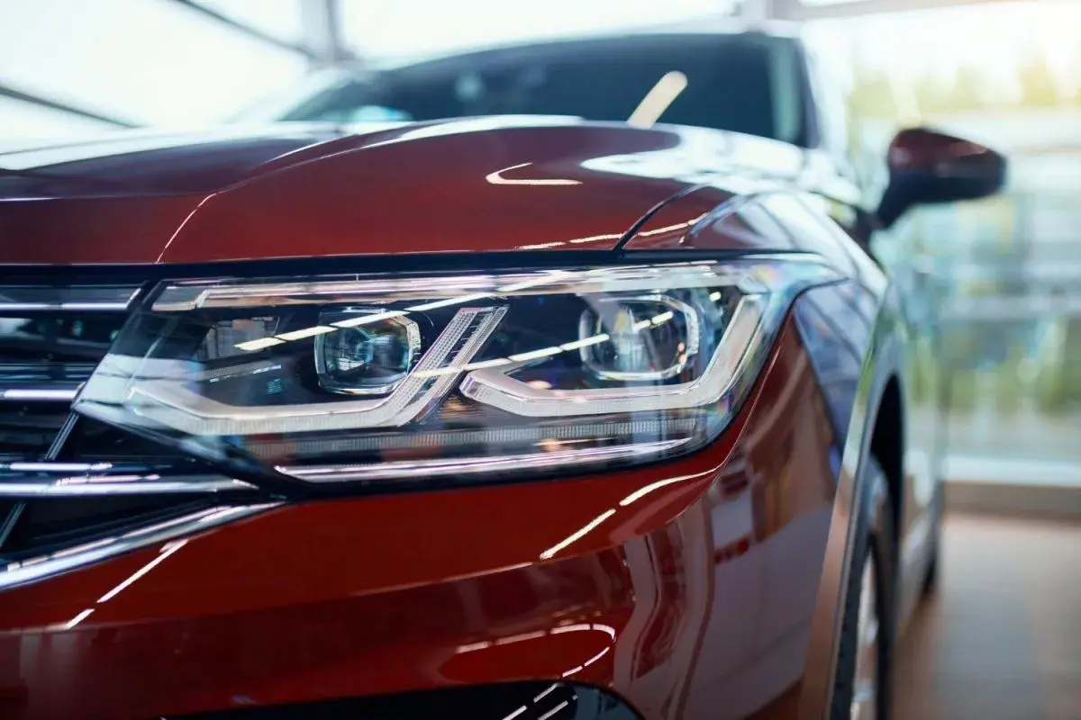 Detalle de faro de coche rojo con luces LED y catadióptricos que reflejan la luz.