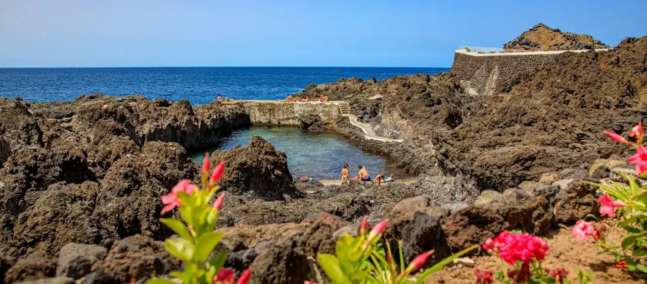 Naturschwimmbecken mit Menschen, umgeben von Lavafelsen. Ein toller Tipp für Ihren Teneriffa Urlaub!