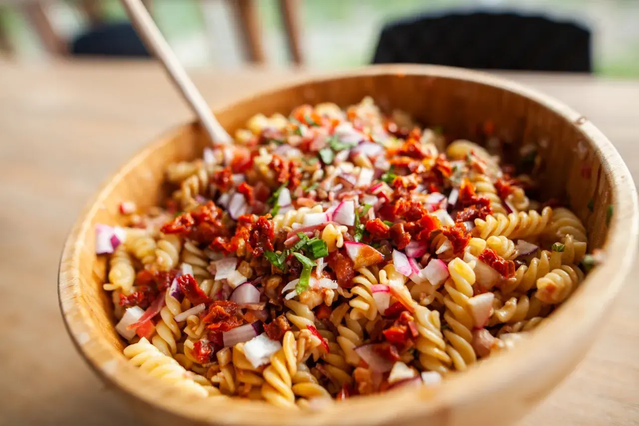 Pasta fredda da portare a lavoro, un'insalata colorata con fusilli, pomodori secchi, cipolla rossa e ravanelli. Perfetta per un pranzo gustoso.
