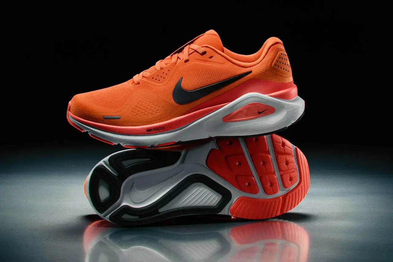 Pomarańczowe obuwie sportowe męskie Nike z czarnym logo. Idealne do biegania, zapewniające komfort i dynamikę.