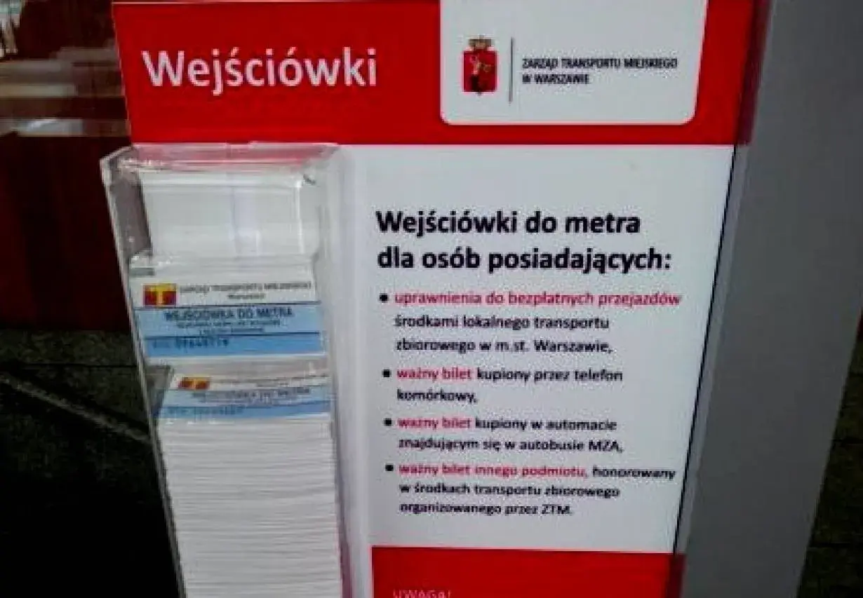 Informacja o tym, jak kupić bilet na metro w Warszawie. Stojak z ulotkami "Wejściówki do metra" i informacją o uprawnieniach.
