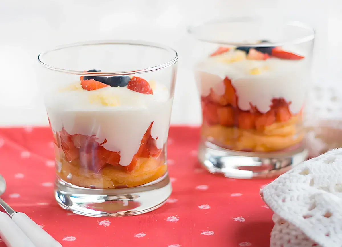 Delicioso tiramisú de fresa en capas, con bizcocho, fresas, crema y arándanos.