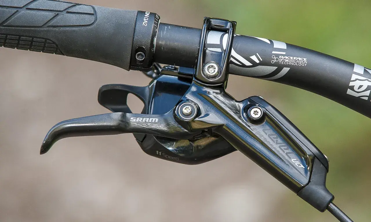 Close-up of a SRAM Level Ultimate brake lever on a mountain bike handlebar, ready for any trail.
