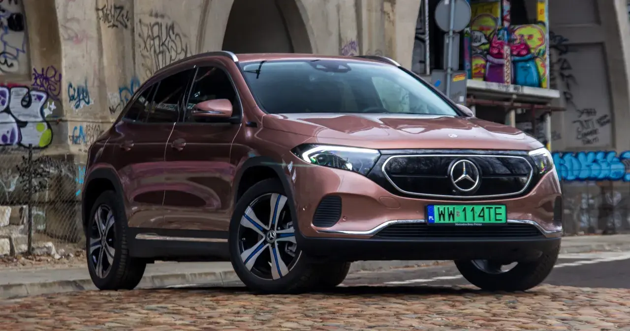 Różowy Mercedes EQA na tle graffiti.