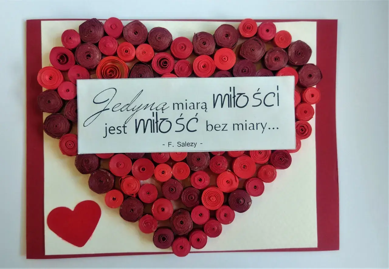 Walentynka dla chłopaka: serce z czerwonych spirali papieru i cytat "Jedyną miarą miłości jest miłość bez miary...".