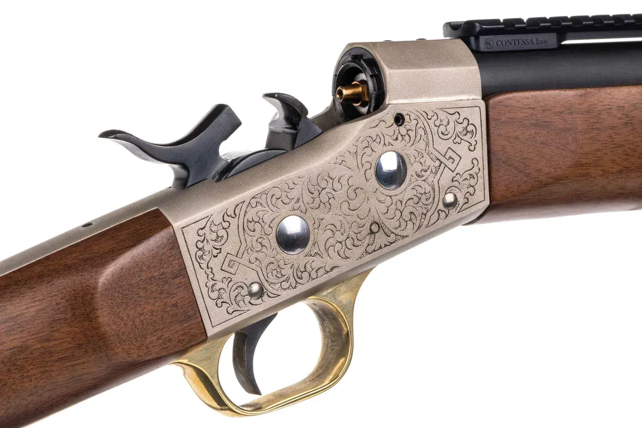 Elegancki karabin z grawerowanym zamkiem typu rolling block 50, drewnianą kolbą i mosiężnym językiem spustowym.