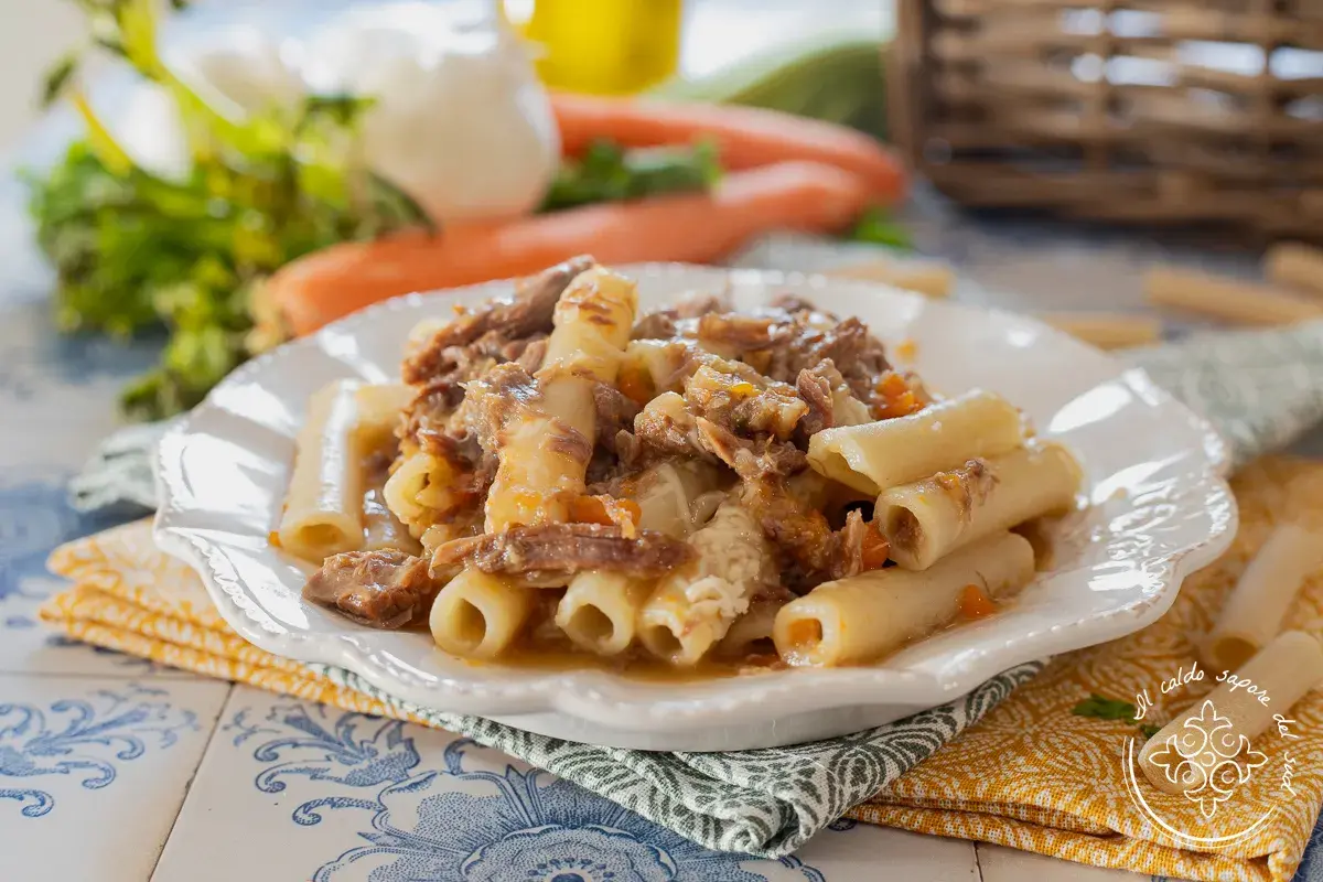 Piatto di ziti alla genovese con ragù di carne sfilacciata e verdure. Un classico della cucina napoletana.