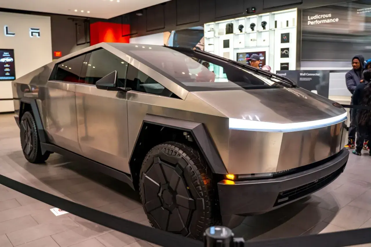 Futurystyczny Cybertruck Tesli błyszczy w salonie, gotowy na przygodę.