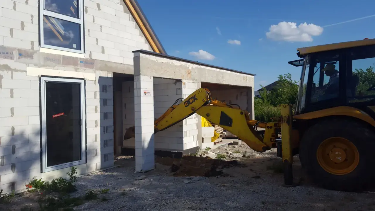 Budowa domu w toku. Koparka pracuje przy fundamentach. Czy wlz czy potrzebny projekt?
