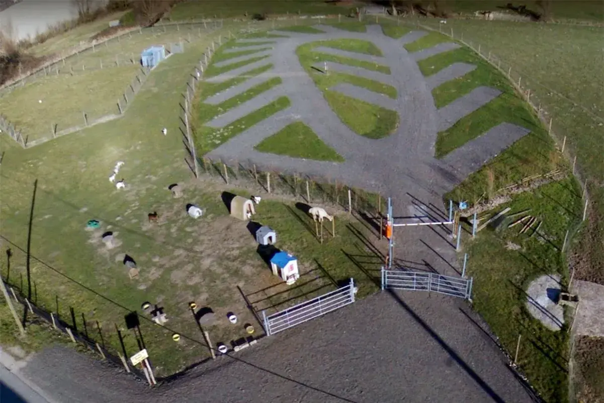 Vue aérienne de la ferme de Bihen avec des animaux, des abris et des emplacements de camping aménagés.
