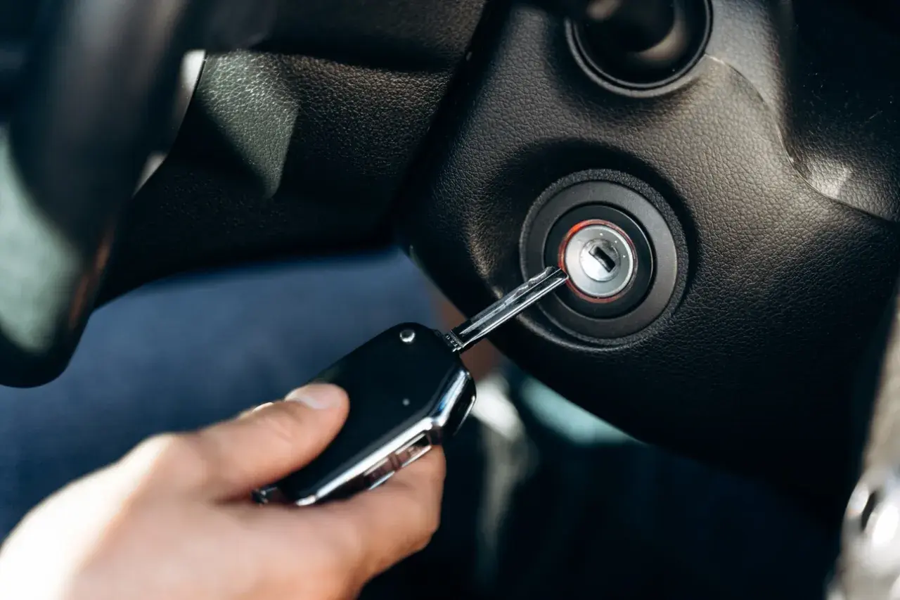Kluczyk próbuje uruchomić auto, ale stacyjka wygląda na uszkodzoną. Objawy uszkodzonej kostki stacyjki mogą być frustrujące.