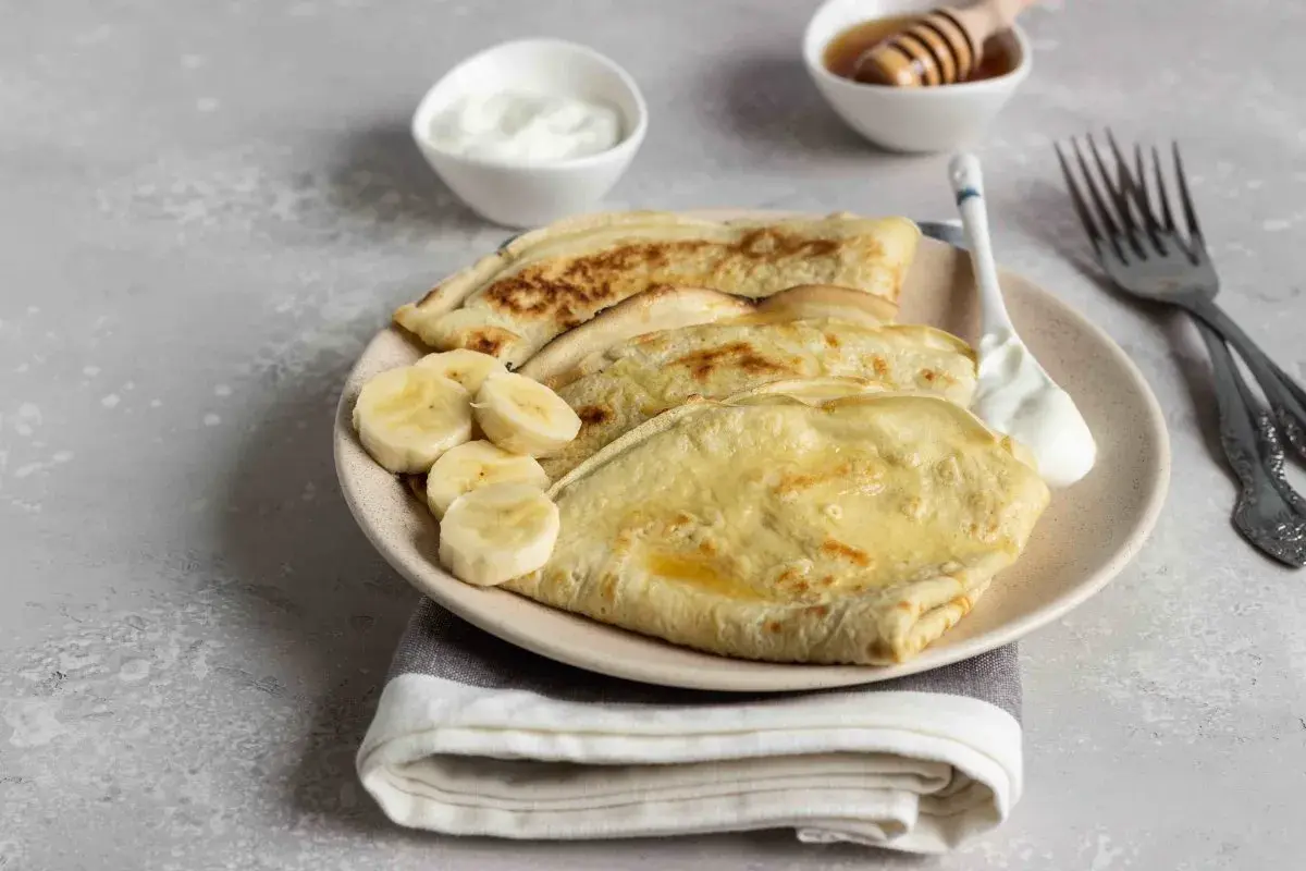 Omlet z bananem, podany z jogurtem i miodem, to idealne śniadanie.