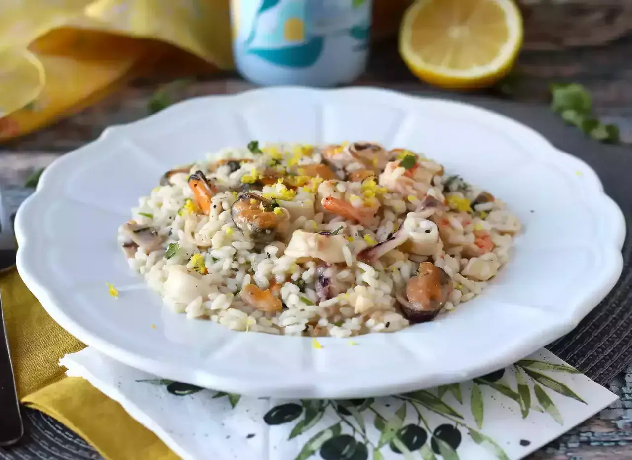 Un délicieux risotto fruits de mer crémeux, garni de zestes de citron et de persil frais.