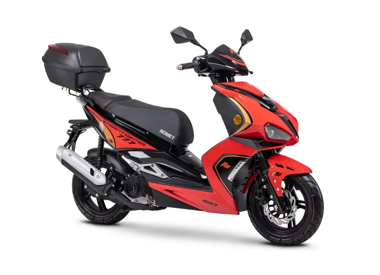 Czerwony skuter Romet z czarnym siedzeniem i kufrem. Idealny do miasta, do jakiej pojemności można jeździć motorem bez prawa jazdy?