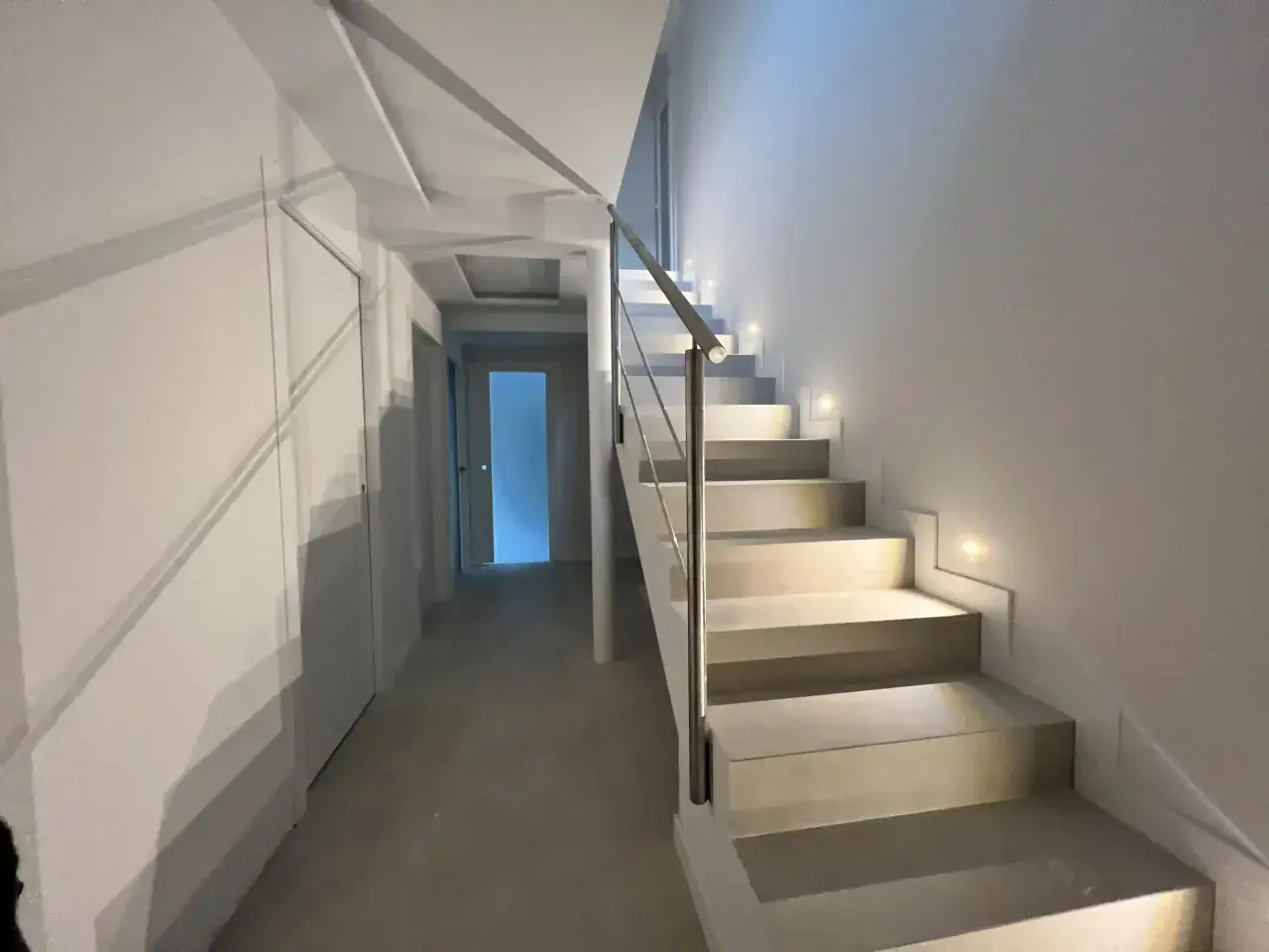 Iluminación peldaños escalera moderna, con luces empotradas que guían el camino.