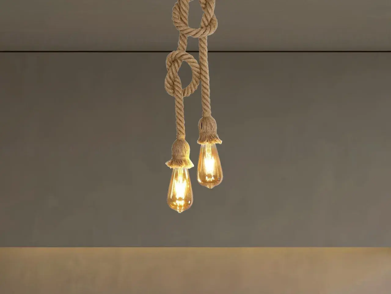 Dos lámparas de cuerda con bombillas Edison cuelgan del techo, creando un ambiente rústico y cálido.