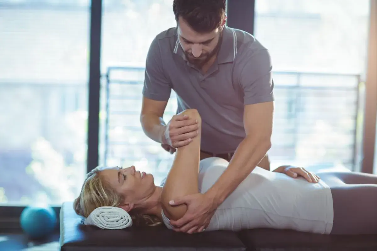 Fizjoterapeuta wykonuje ćwiczenia z pacjentką. Rehabilitacja i fizjoterapia pomagają w powrocie do zdrowia.