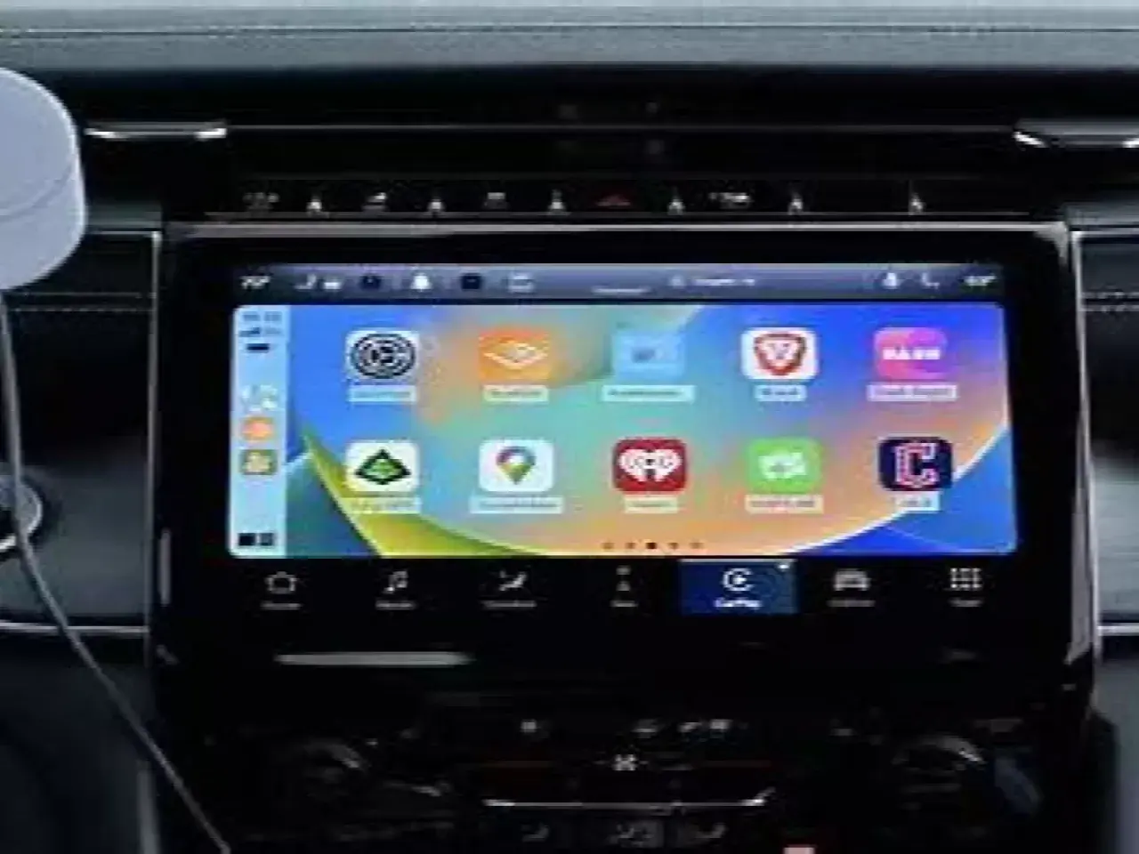 Ekran samochodu z ikonami aplikacji, w tym nawigacją i muzyką. To właśnie co to jest CarPlay – integracja telefonu z autem.