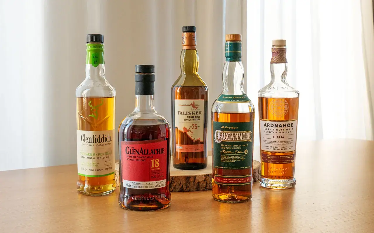Fünf Flaschen verschiedener Whisky-Sorten stehen nebeneinander: Glenfiddich, Glenallachie, Talisker, Cragganmore und Ardnahoe.