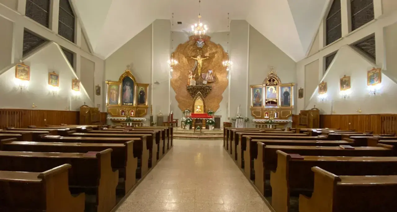 Wnętrze kościoła z ławkami i ołtarzem. Niech będzie pochwalony Jezus Chrystus.