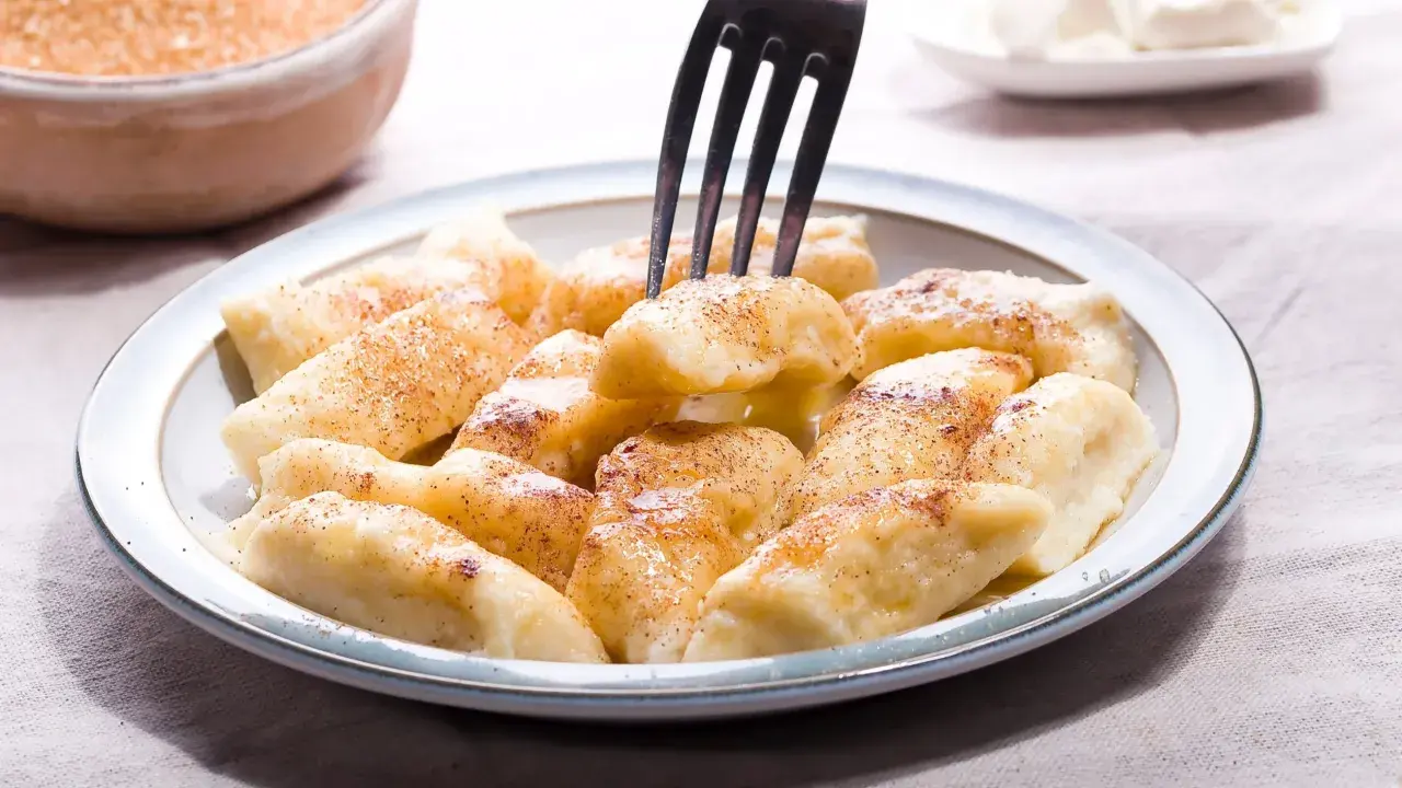 Pyszne pierogi leniwe posypane cynamonem, gotowe do jedzenia. Idealne na szybkie śniadanie lub deser.