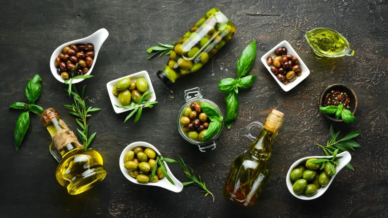 Diverse olive, in ciotole e bottiglie, con olio e basilico. Chissà quanto pesa un oliva, ma sono perfette per un antipasto.