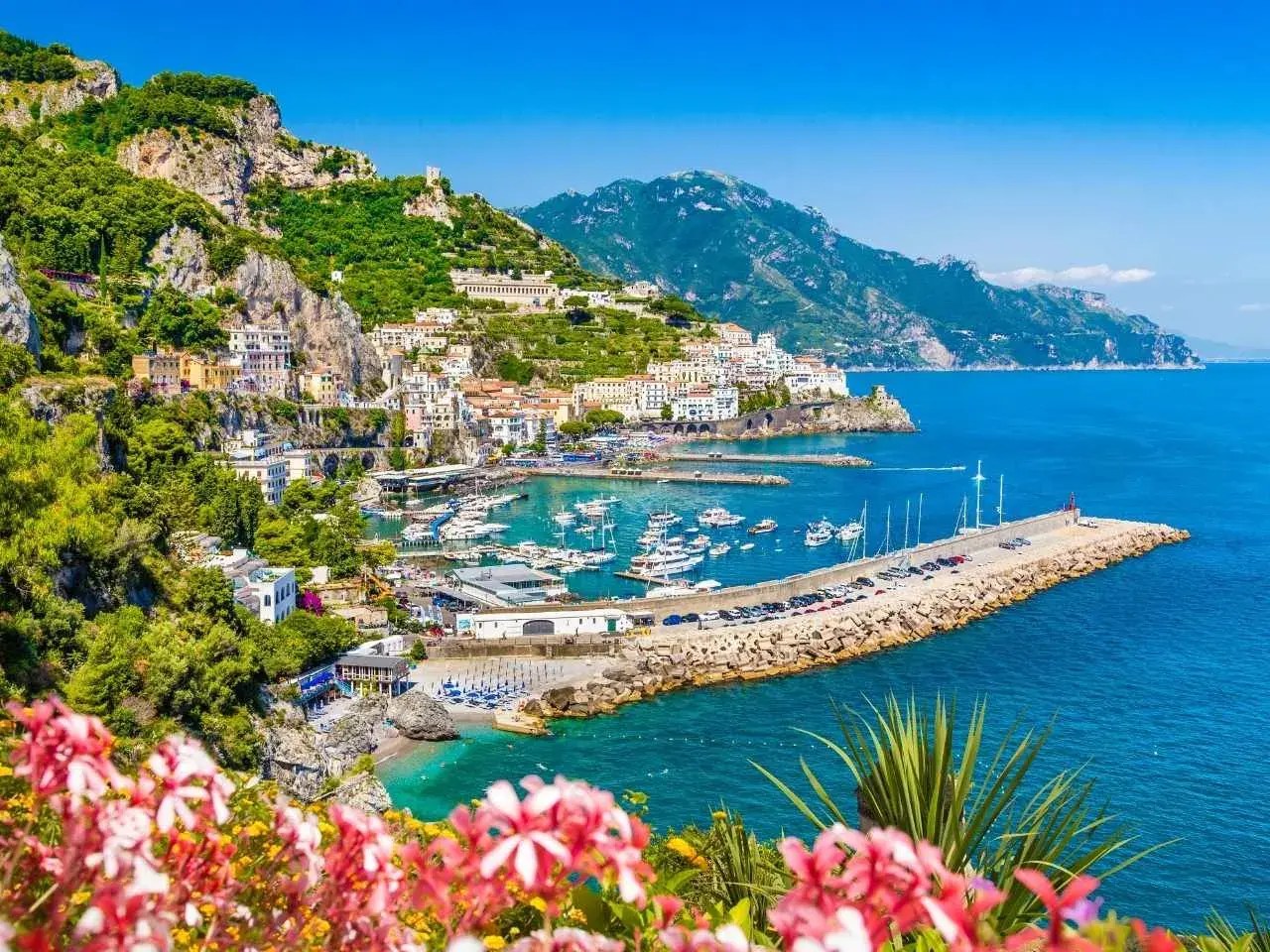 Malowniczy widok na wybrzeże Amalfi, idealne miejsce na neapol na weekend. Woda lśni, a domy wspinają się po zboczu.