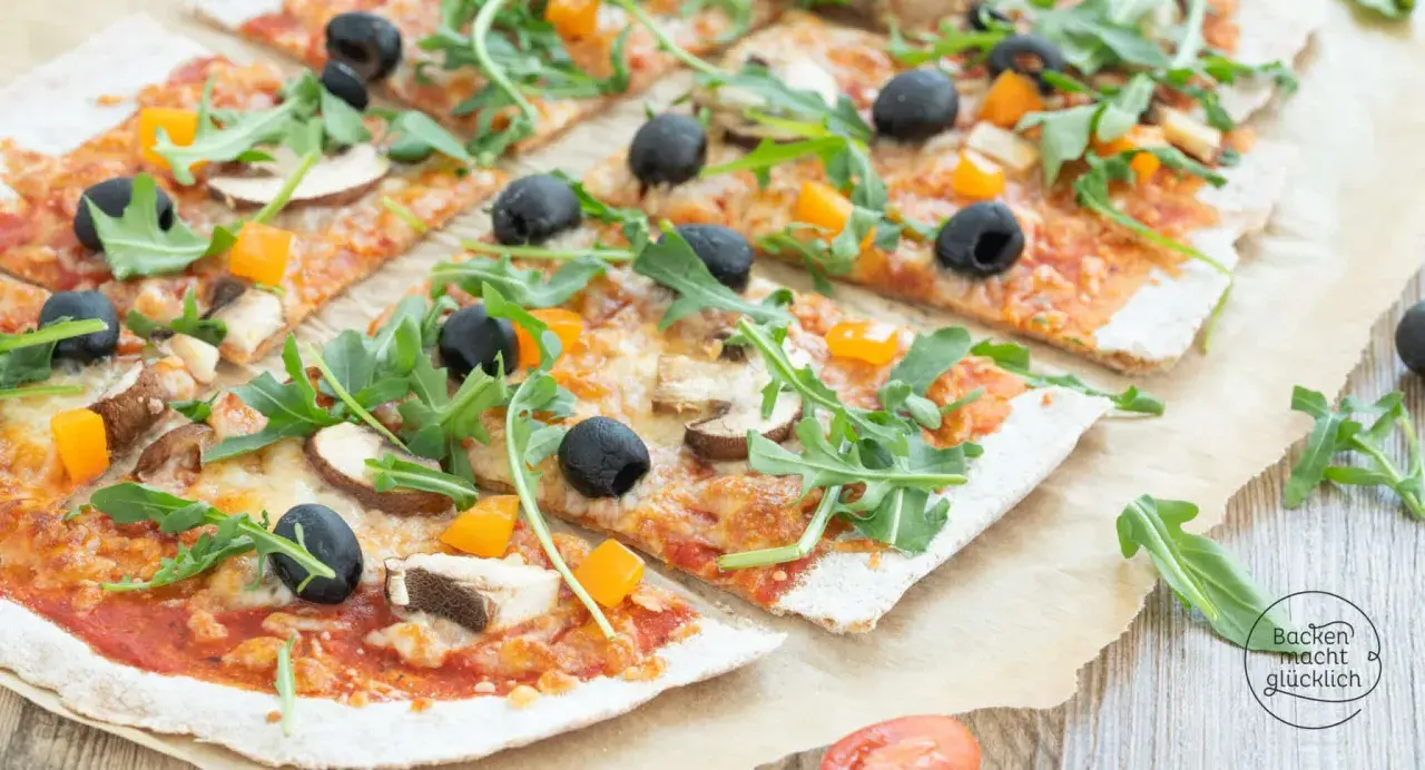 Eine leckere vollkorn pizza mit Pilzen, Oliven und Rucola, belegt mit geschmolzenem Käse und Paprikawürfeln.