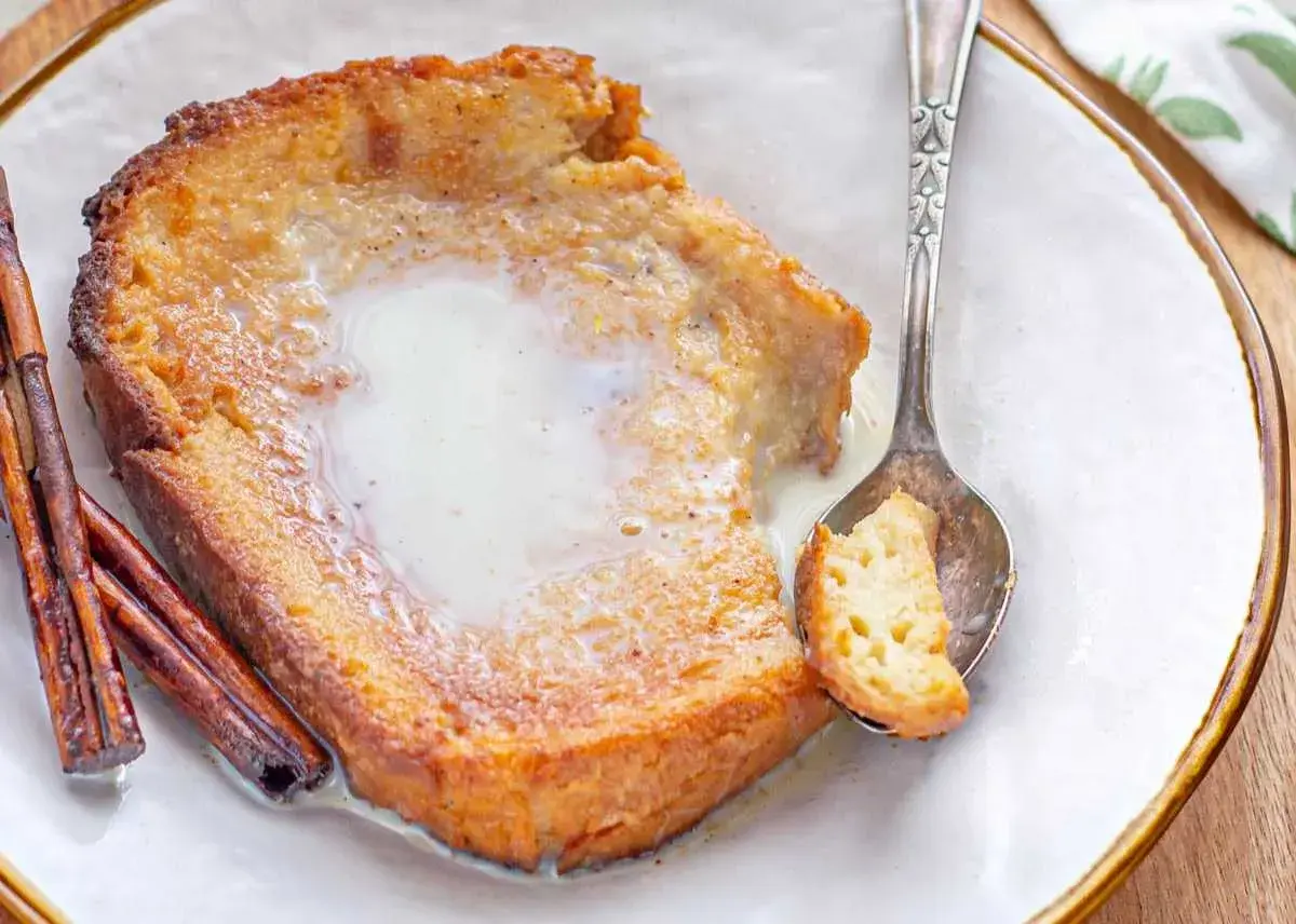 Torrijas con leche condensada, un postre casero con canela y una cuchara lista para probar.