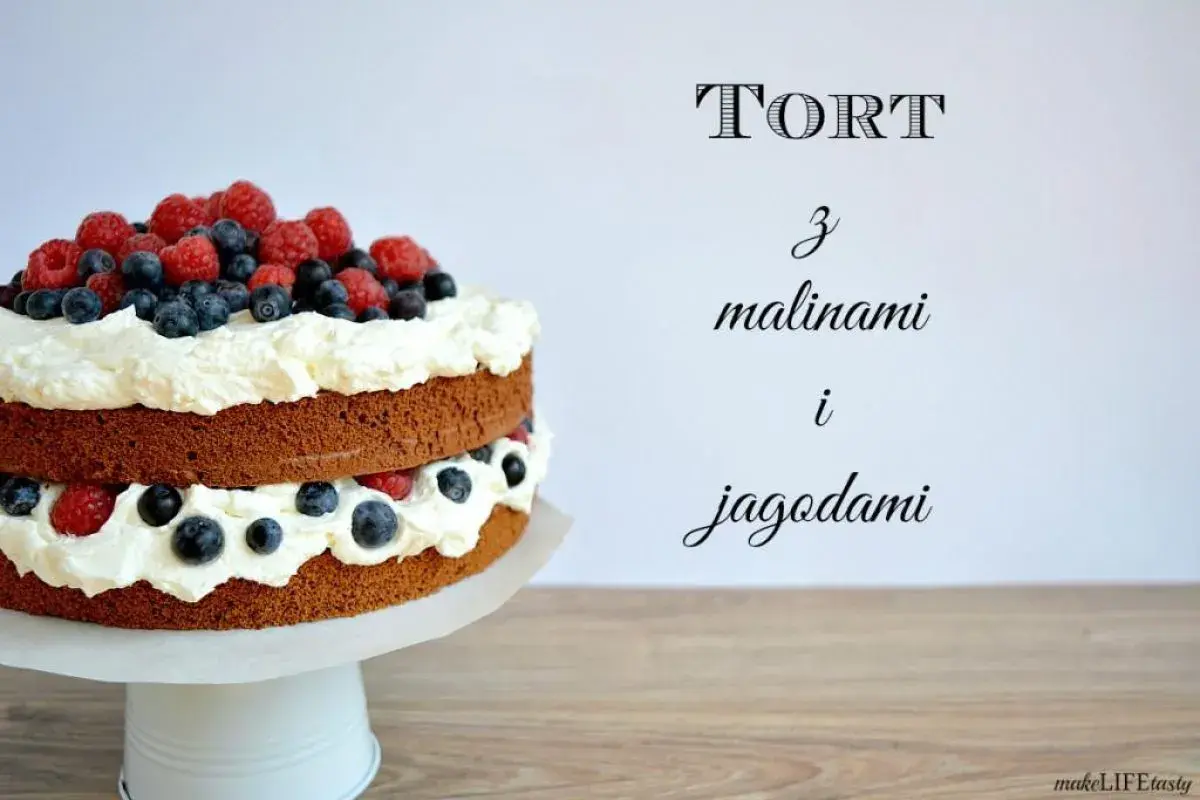 Dwupoziomowy tort z bitą śmietaną, malinami i jagodami, ozdobiony świeżymi owocami na wierzchu. Idealny na letnie przyjęcie.