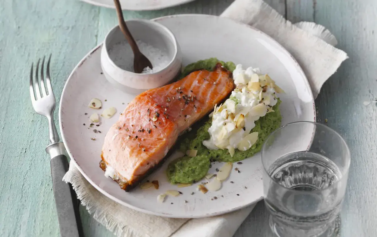 Pavé de saumon poêlé, purée de petits pois, fromage frais et amandes effilées. Une recette simple et savoureuse.